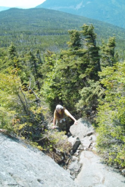 scrambling up a steep, rocky section of a trail